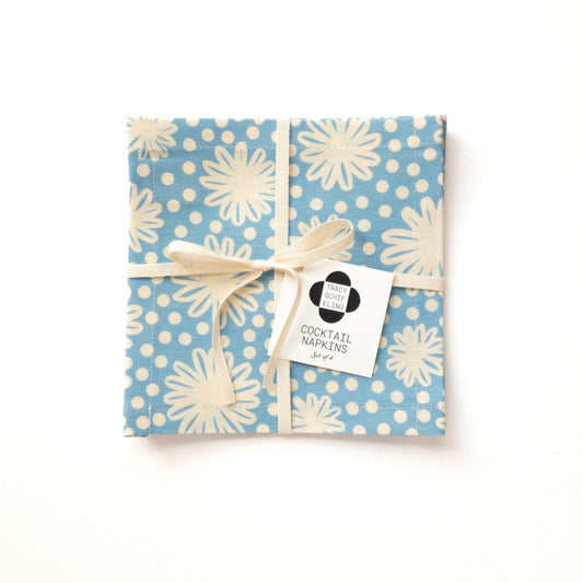 Packaged cocktail napkin set with blue and white floral pattern on a white background