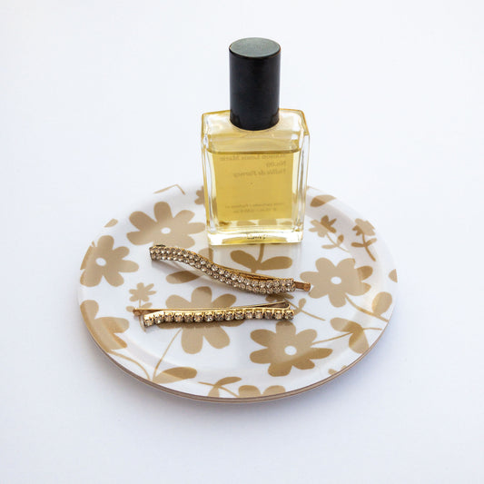 Perfume bottle on a floral patterned coaster