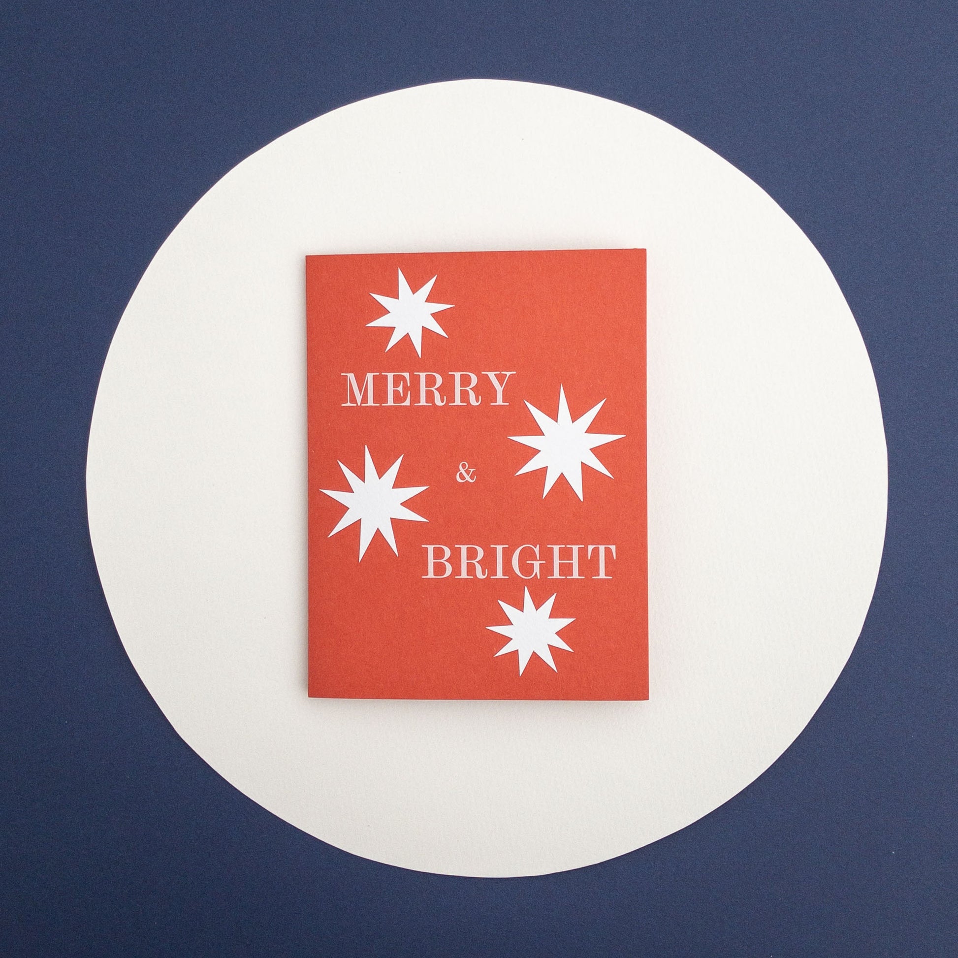 Red card with white stars and 'Merry & Bright' text on a blue background