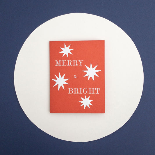 Red card with white stars and 'Merry & Bright' text on a blue background
