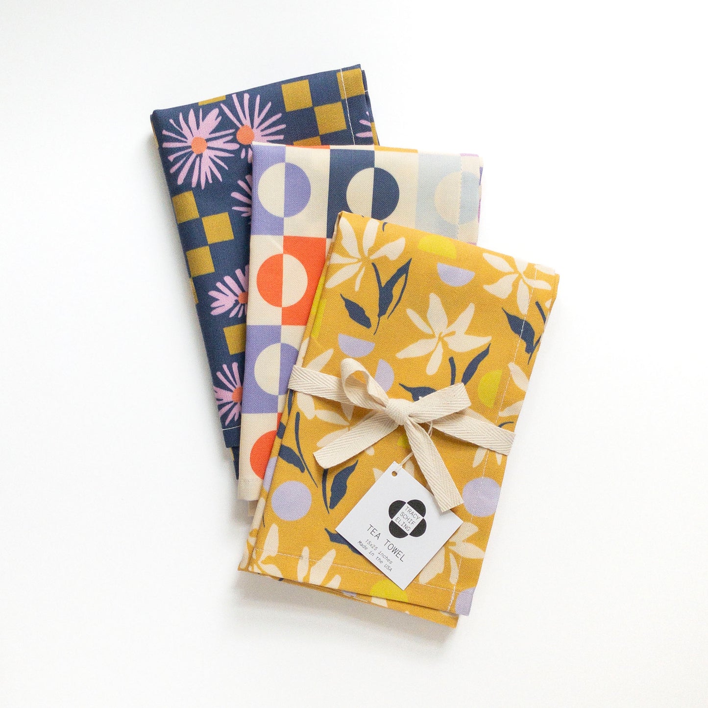 Three colorful and patterned tea towels on a white background