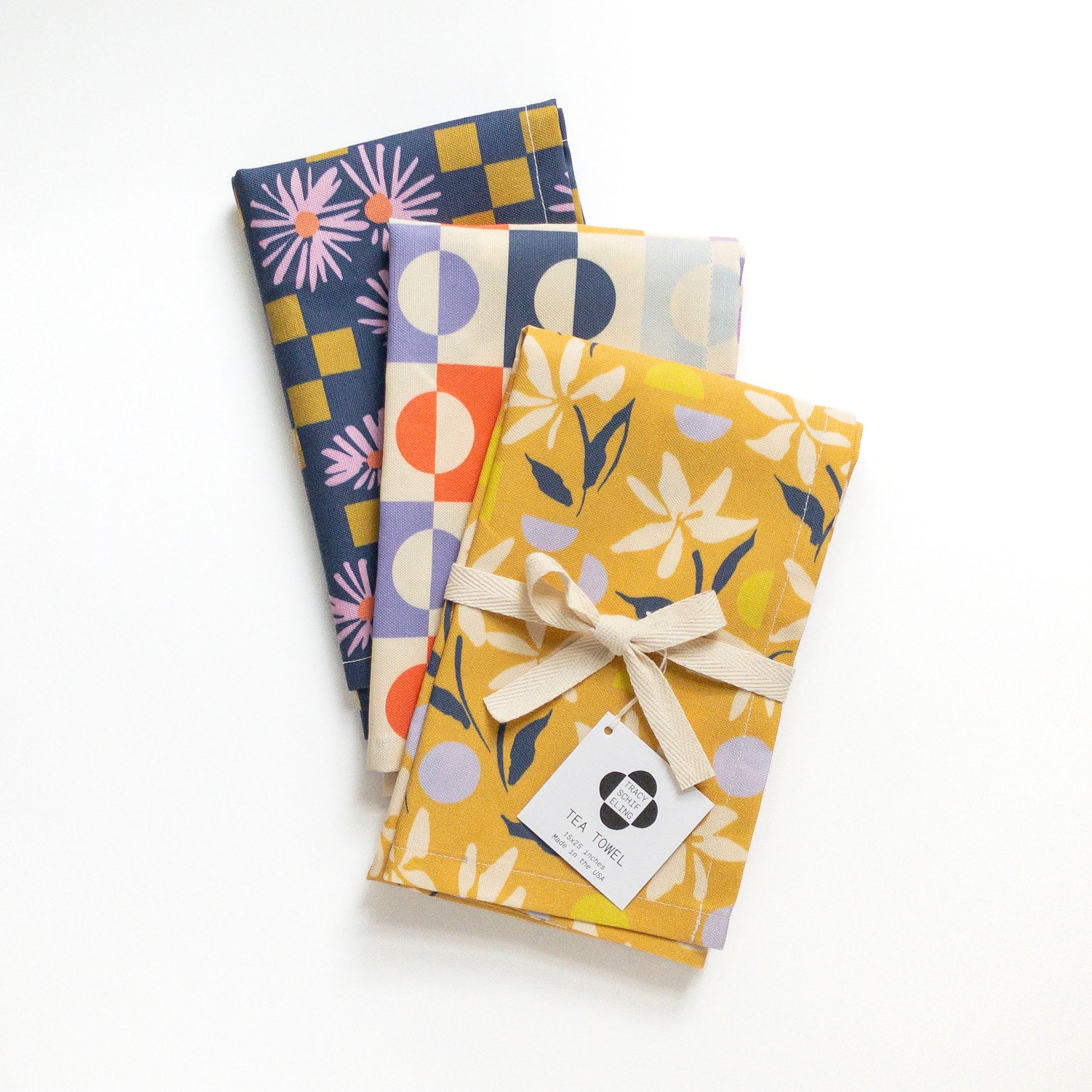 Three colorful and patterned tea towels on a white background