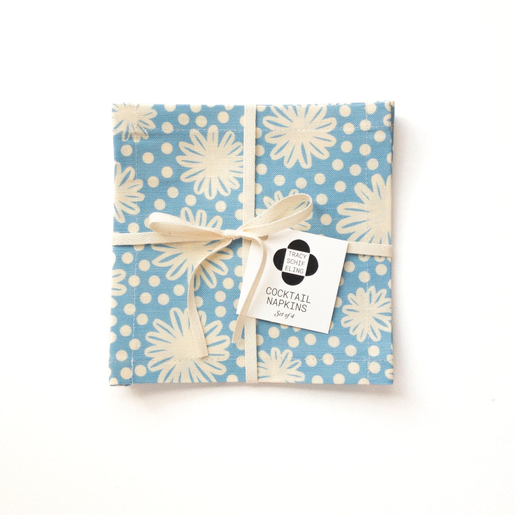 Packaged cocktail napkin set with blue and white floral pattern on a white background