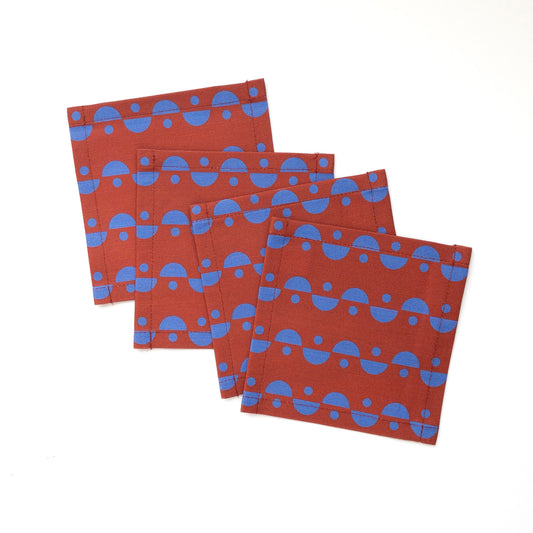 Set of four blue and brown cocktail napkins on a white background