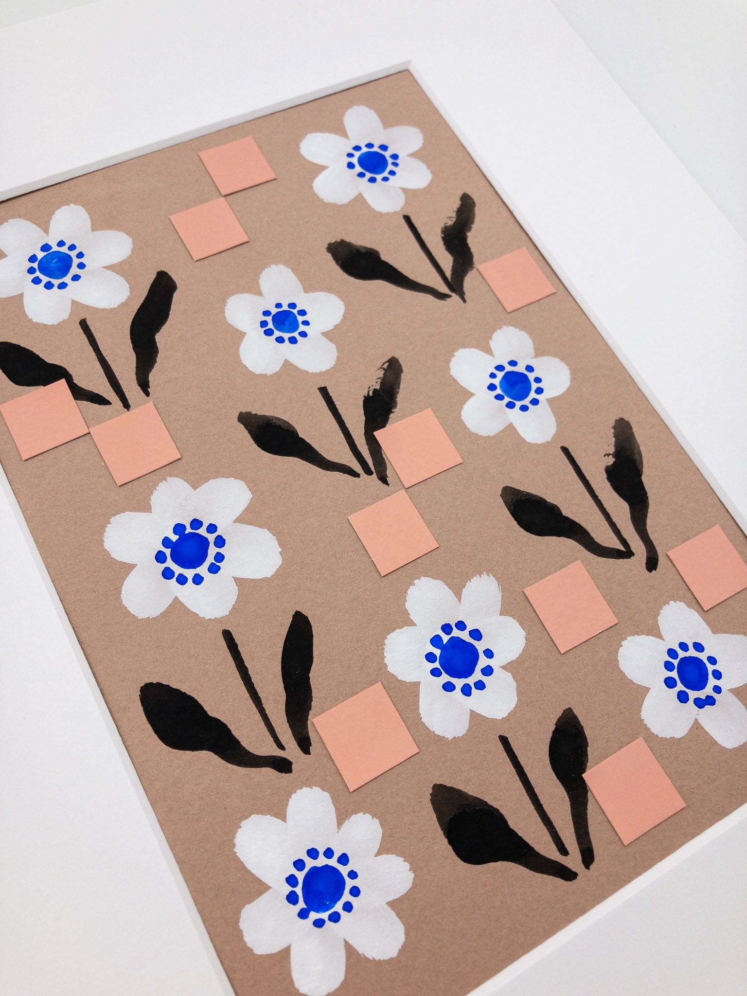 Angled photo of a floral painting with repeating square motif.
