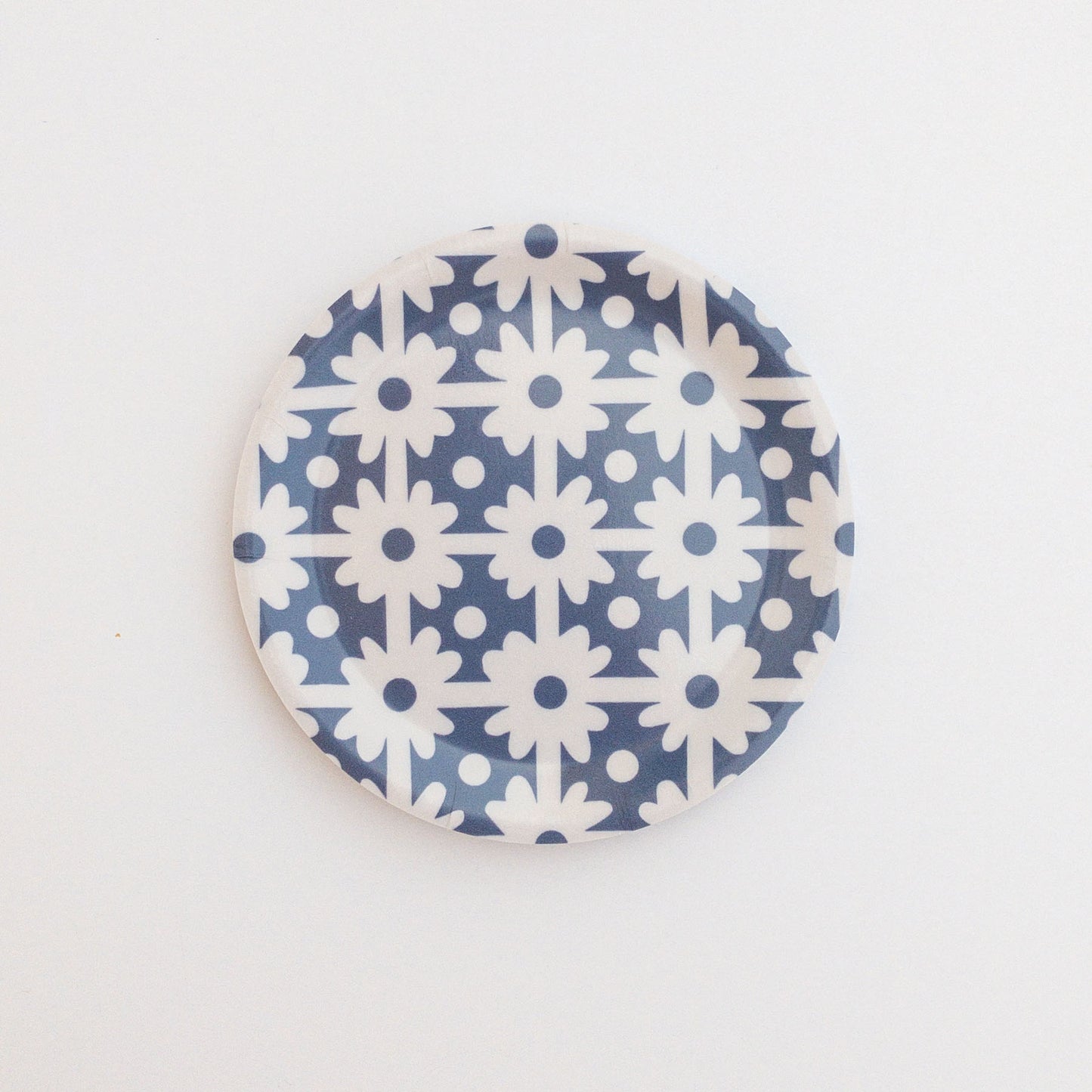 Round coaster with blue and white floral grid pattern on a white background.