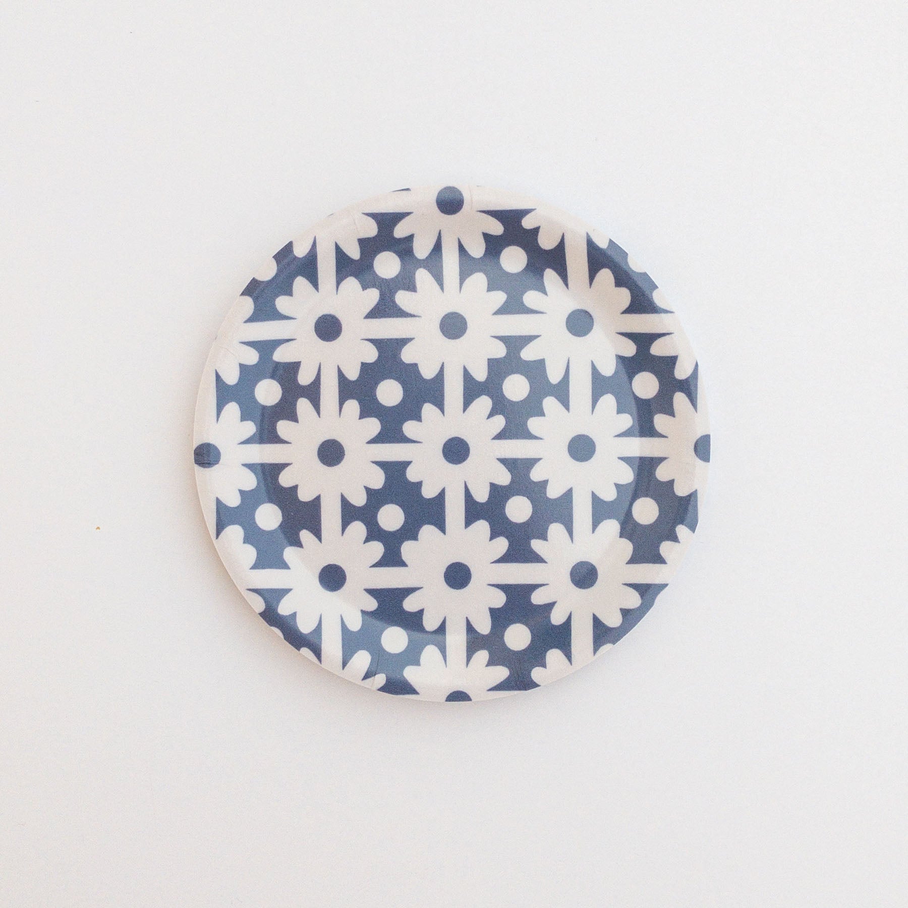 Round coaster with blue and white floral grid pattern on a white background.