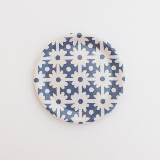 Round coaster with blue and white floral grid pattern on a white background.