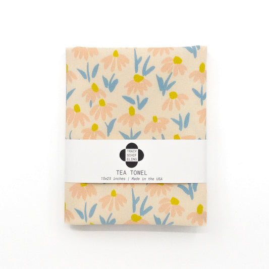 Folded and packaged tea towel featuring a pattern of coneflowers or daisies.