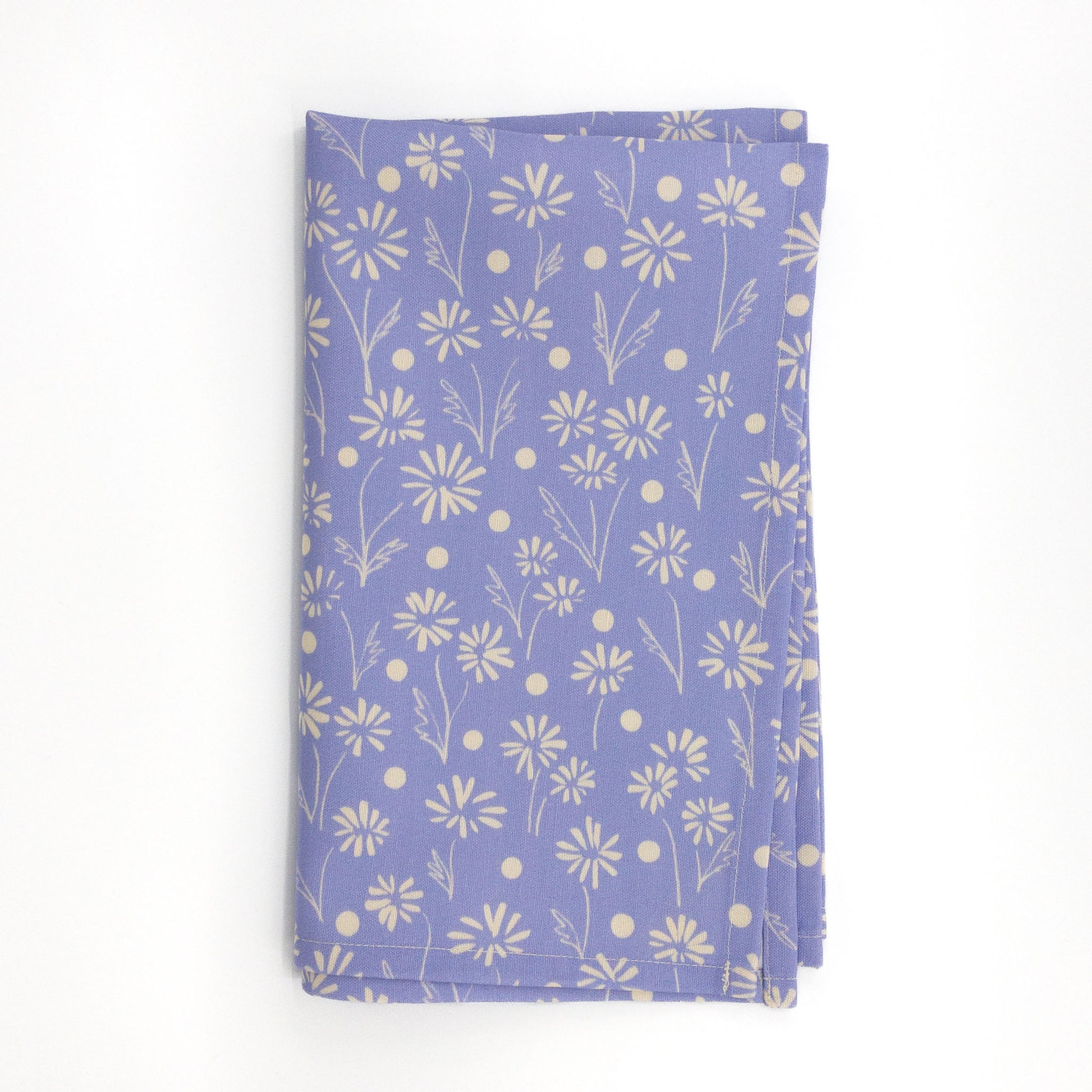 Folded blue floral tea towel featuring a hand-drawn daisy and dot design on a white background.