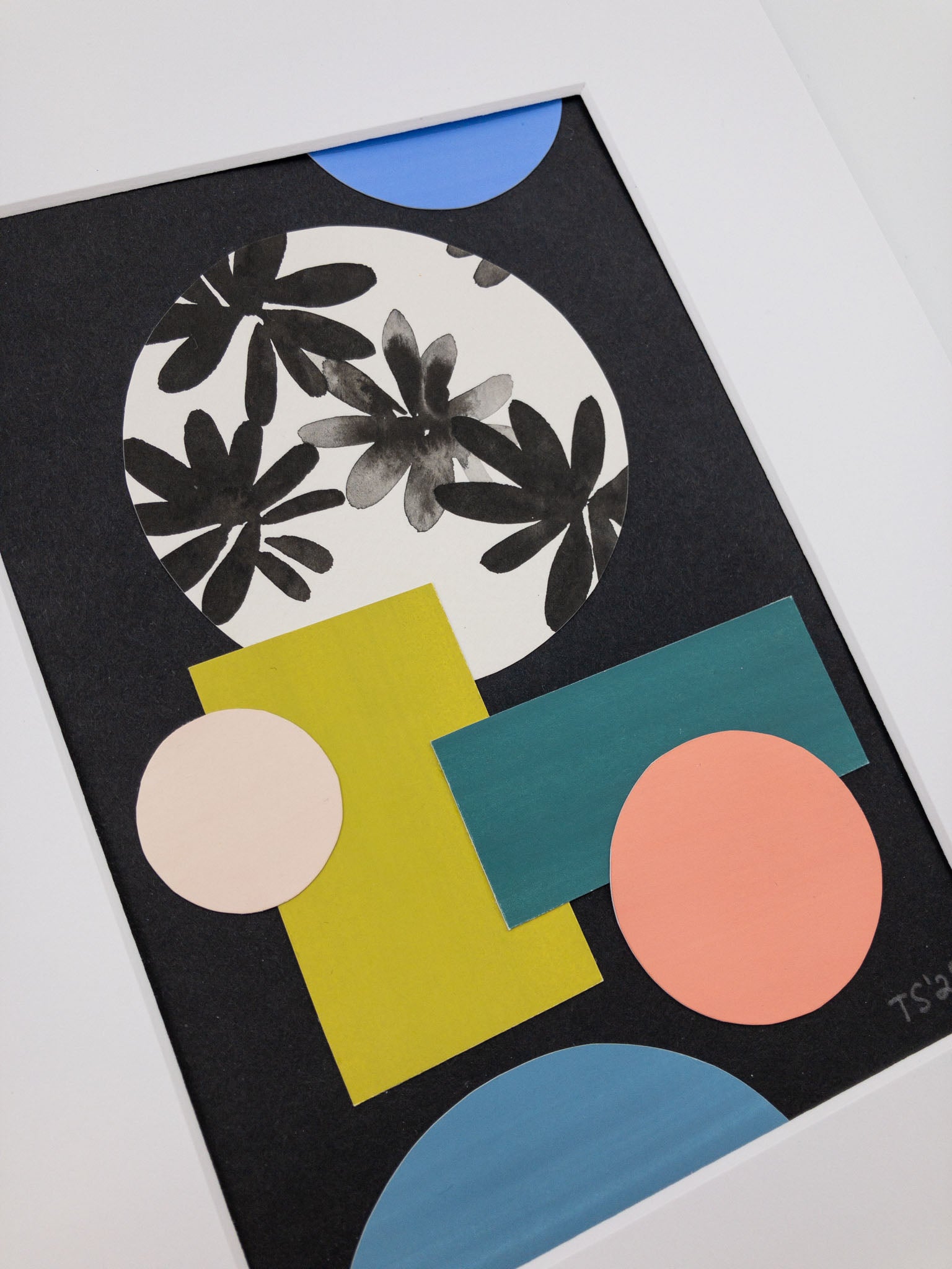 Angled photo of a colorful geometric collage on a black background.