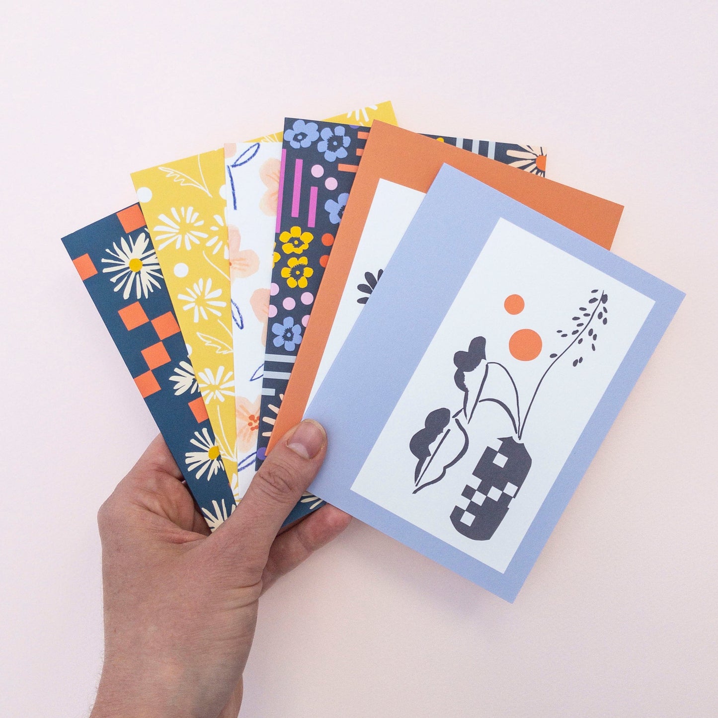 Set of six colorful greeting cards with floral and abstract designs on a white background.