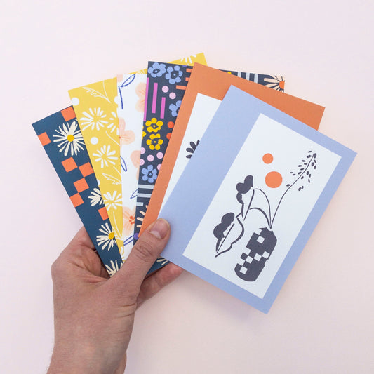Set of six colorful greeting cards with floral and abstract designs on a white background.