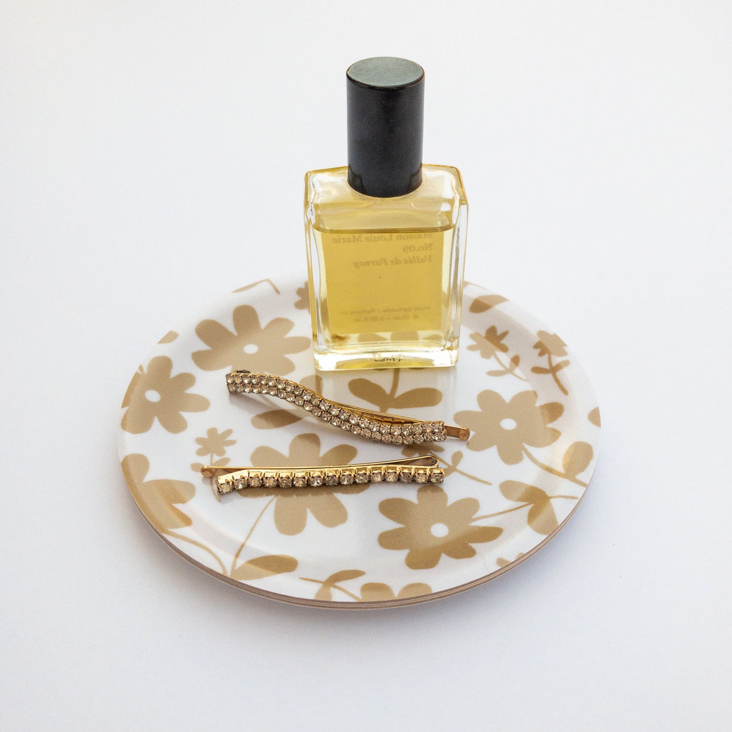 Perfume bottle on a floral patterned coaster