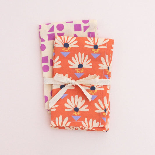 Two folded tea towels tied with a ribbon.