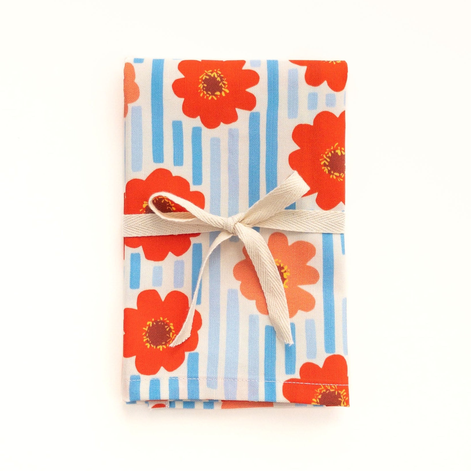 Tea towel with floral zinnia design and striped pattern on a white background.